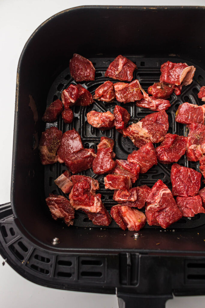 Steak bite pieces in the basket of an air fryer.